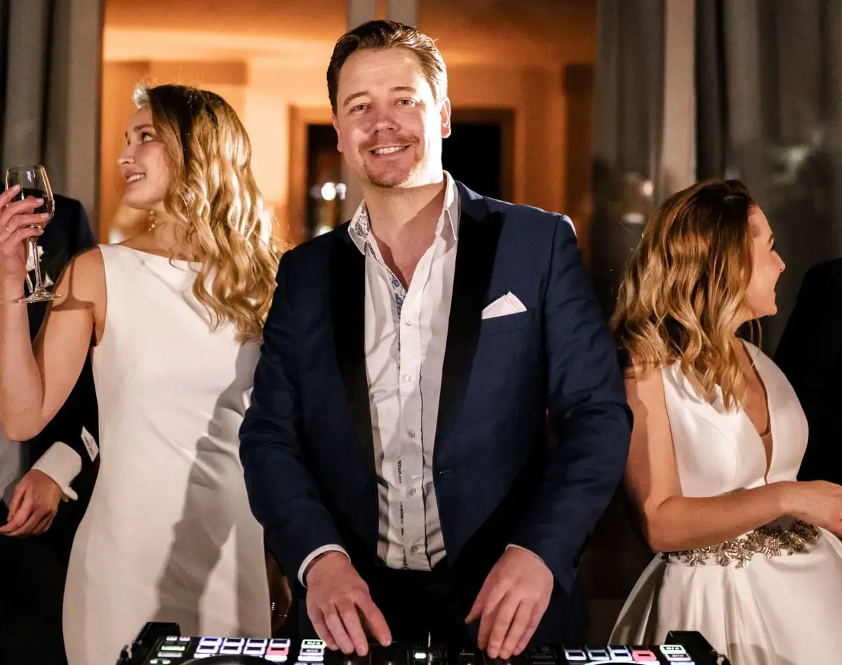 DJ Chris Force am DJ-Controller, daneben tanzende Gäste mit Sektgläsern – Event im Rhein-Main-Gebiet