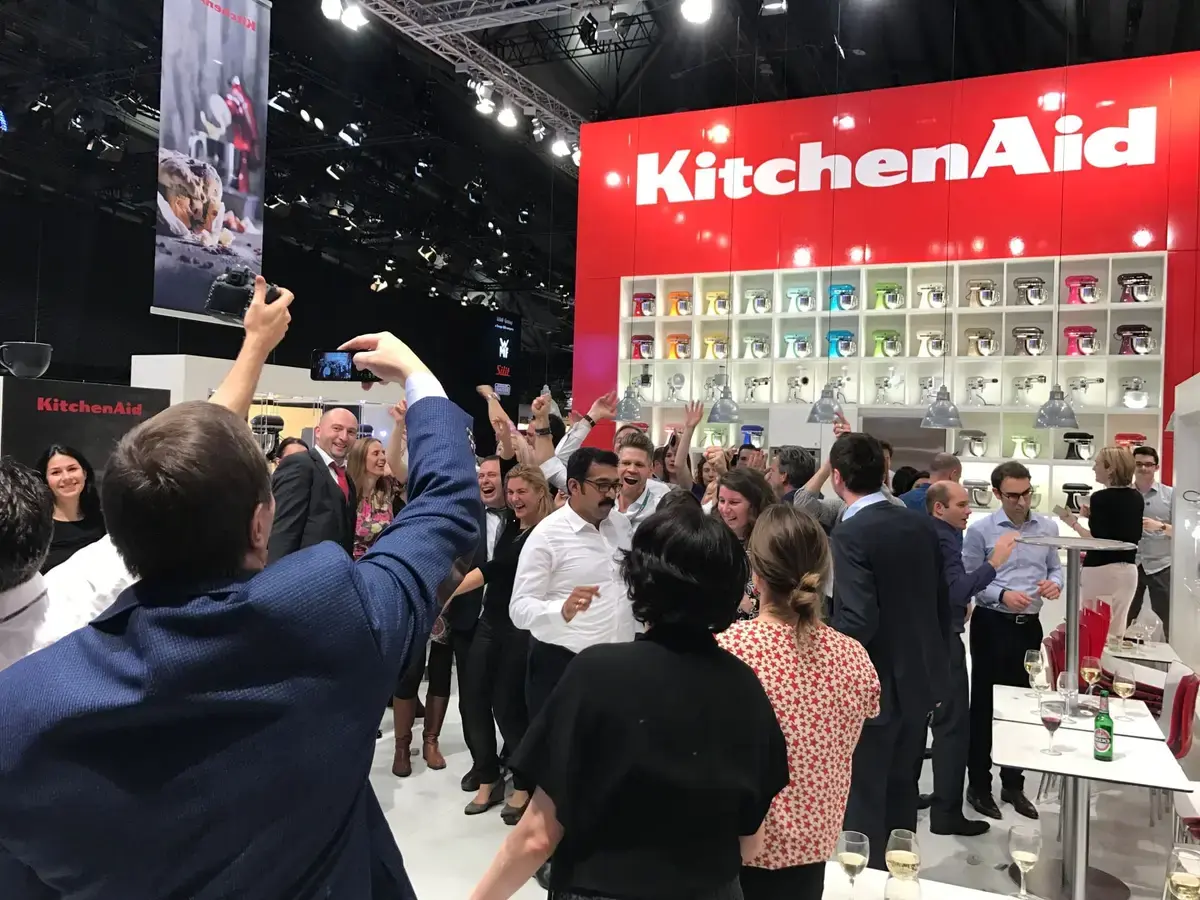 Standparty auf einem Messestand mit vielen Gästen, Gläsern und Spotlights – Messe-Event mit DJ Chris Force in Frankfurt
